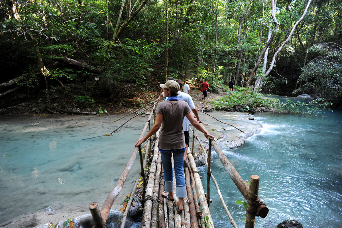 Indonoceans guest crossing wooden bridge, Moyo Island, Sumbawa